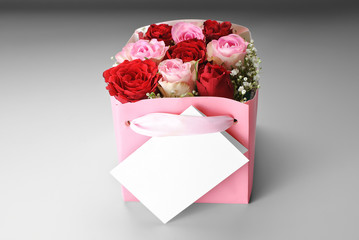 Blank greeting card over decorative box of roses