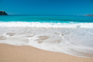 Beautiful surf on the beach. Mountains on the horizon.