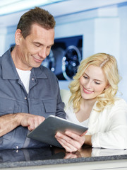 Customer and mechanic in a garage looking at a quotation