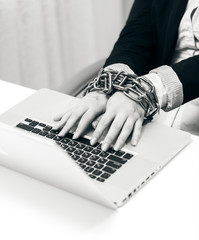 closeup photo of woman locked to laptop by chain