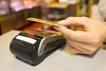Woman paying with NFC technology on credit card in supermarket