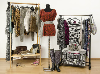 Dressing closet with animal print clothes arranged on hangers. - 64860912