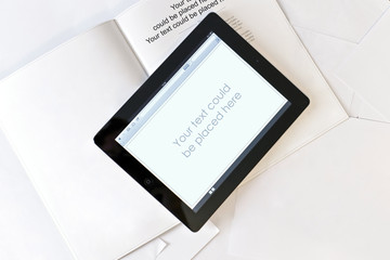 Tablet computer on book with blank pages