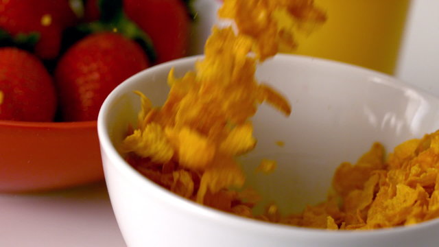 Cereal pouring into a bowl at breakfast table