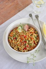 Portion of homemade quinoa salad with vegetables and lemon