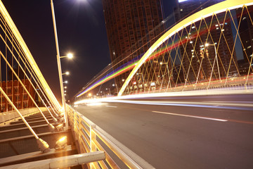Fototapeta na wymiar Arc bridge girder highway car light trails city night landscape