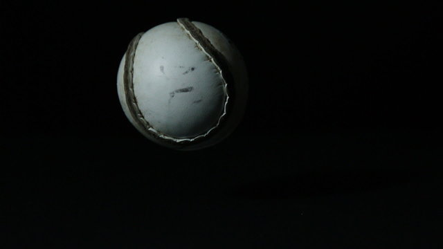 Sliothar falling on black background