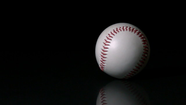 Baseball spinning on black surface