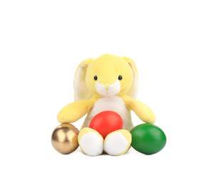 Yellow toy rabbit with easter eggs.