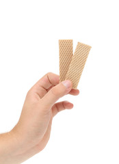 Hand holds wafer of chocolate.