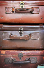 Vecchie valigie in pelle impilate in verticale