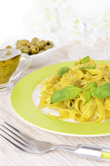 Delicious pasta with pesto on plate on table close-up