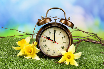 Alarm clock on green grass, on nature background