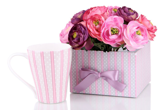 Cup and box with flowers close-up isolated on white