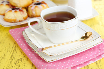 Cup of tea with sweet pastries on table close-up