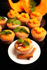 Tasty pumpkin muffins on dark background