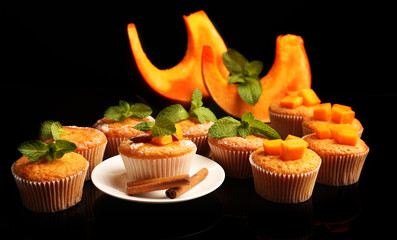 Tasty pumpkin muffins on dark background