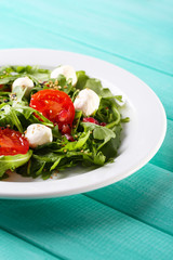 Green salad made with  arugula, tomatoes, cheese mozzarella