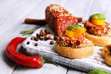 Composition of tasty sandwiches with salami sausage, basil leaf