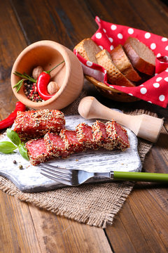Composition of knife,    sliced salami sausage with sesame,