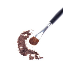Crushed eyeshadow and professional make-up brush isolated
