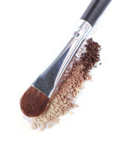 Crushed eyeshadow and professional make-up brush isolated
