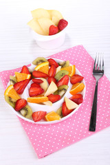 Various sliced fruits on plate on table close-up