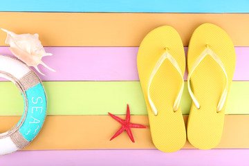 Bright flip-flops on color wooden background
