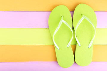Bright flip-flops on color wooden background