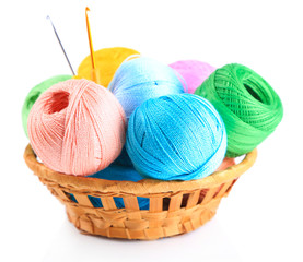 Colorful yarn for knitting in wicker basket and crochet hook,