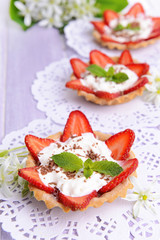 Tasty tartlets with strawberries on table close-up