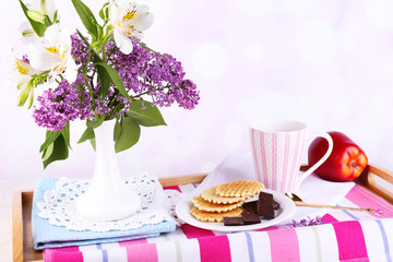 Light breakfast and beautiful bouquet on bed