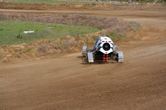 vehiculo buggy blanco a gran velocidad en circuito de tierra