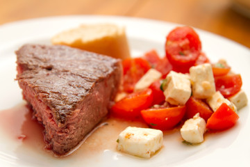 t-bone steak with tomatoes and feta cheese