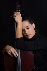 Beautiful brunette holding cello with selective light in black d © Alta Oosthuizen
