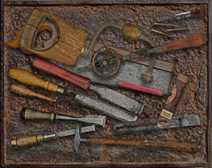 vintage woodworking tools over rusty plate