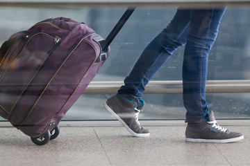 Fototapeta premium Woman carries your luggage at the airport terminal