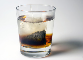 Sugar cubes and tea bag in glass of boiling water