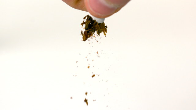 Fingers squeezing and breaking a cigarette