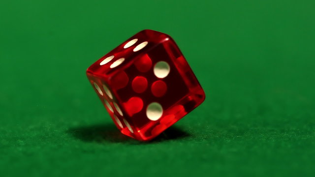 Red dice spinning on casino table
