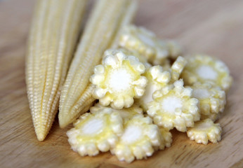 Baby corn cobs on kitchen table © katoosha