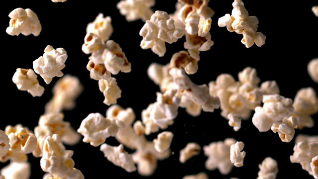 Popcorn bouncing against black background