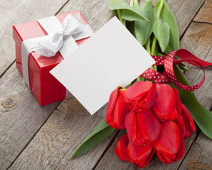 Fresh red tulips with gift box and greeting card