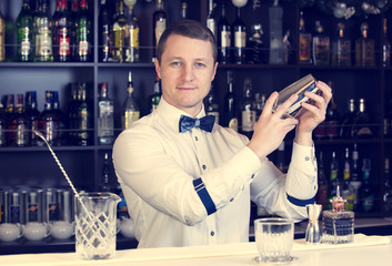 young man working as a bartender in a nightclub bar