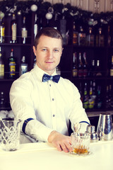young man working as a bartender in a nightclub bar
