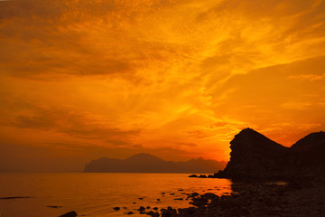 Magic red sunset over rocky coast. Crimea, Ordzonikidze city.