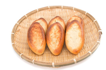 Mini french baguettes in a bamboo plate on white background