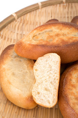 Mini french baguettes in a bamboo plate on white background