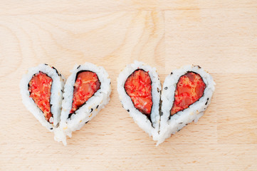 Love sushi concept with four pieces of sushi forming the two hea