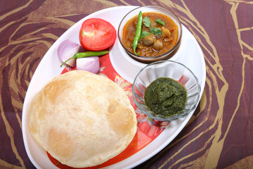 chole bhature with green chutney and chili topping